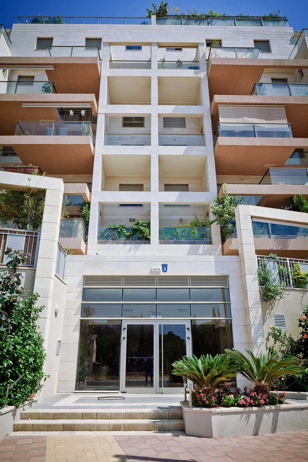 Photograph of the entrance facade of a building in the Aviv project in Alterman - the tower in Herzliya